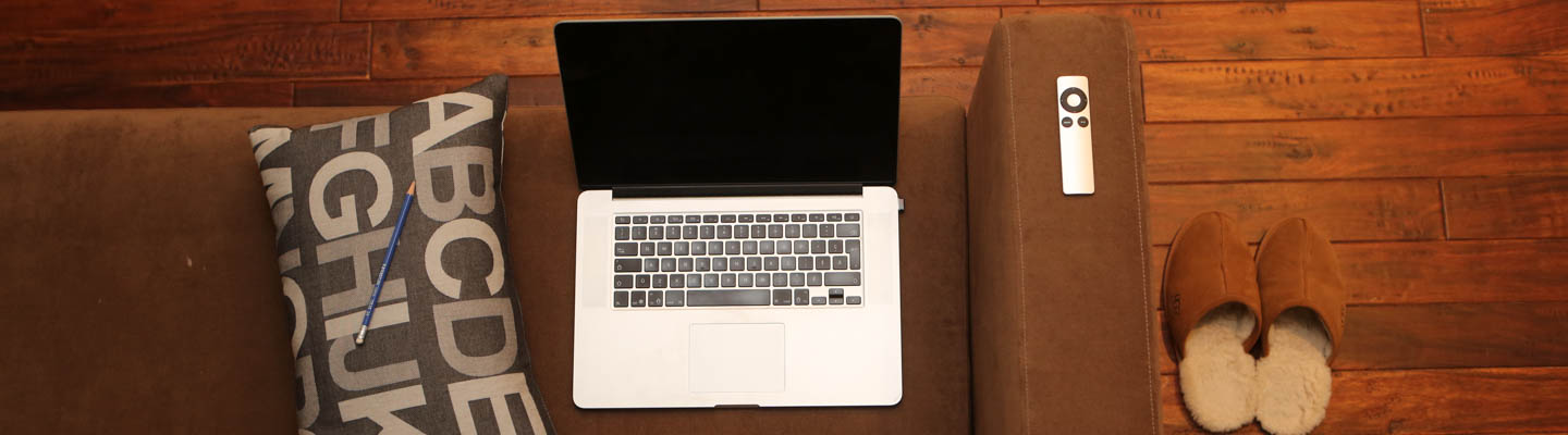 Laptop at desk with pillow and pencil