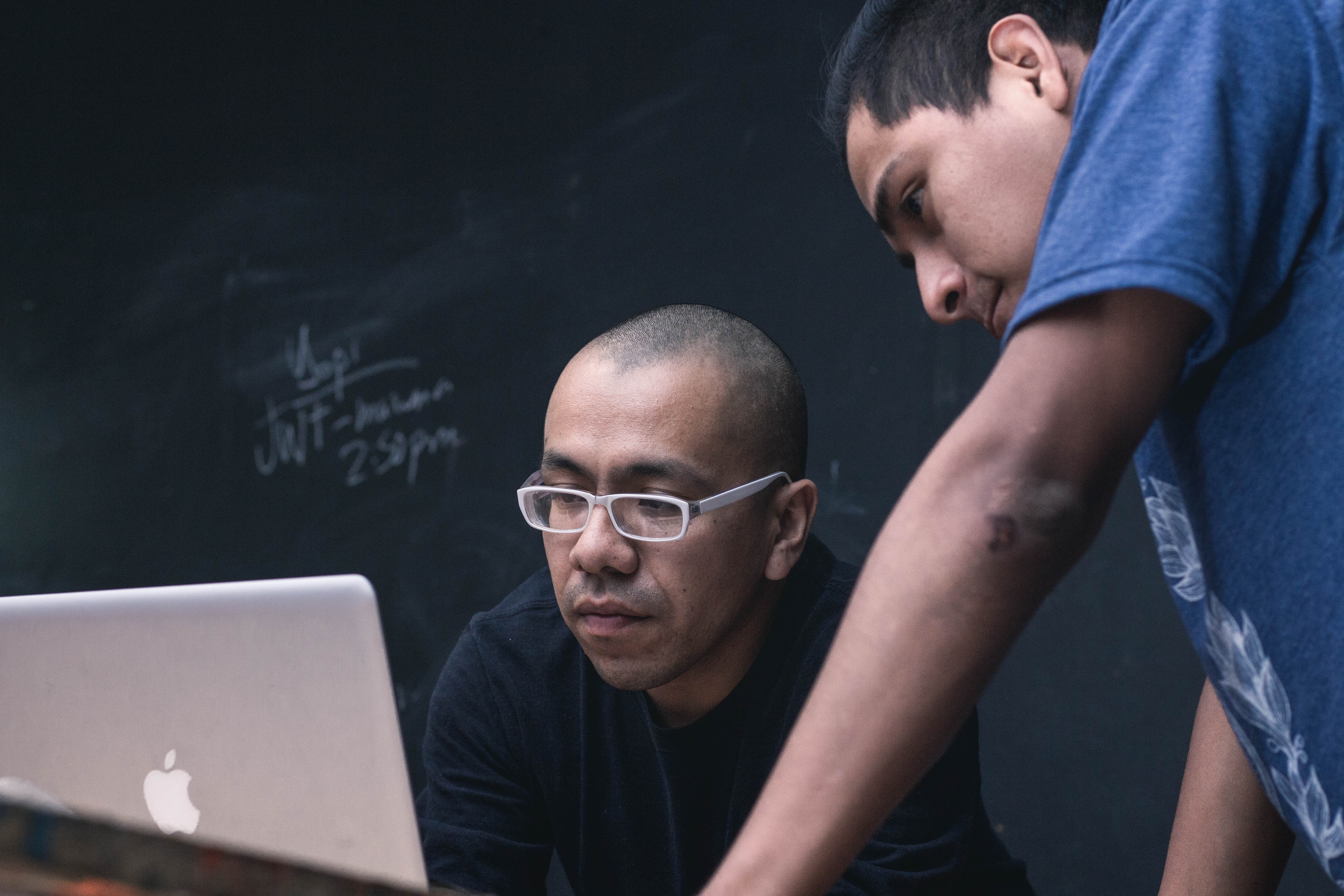 Professor at laptop with student looking at screen