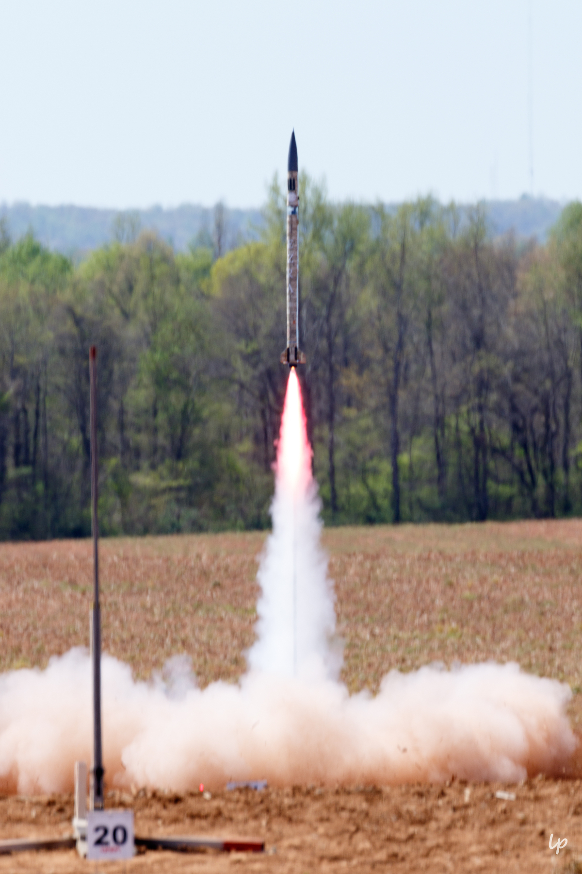 Photo of Cornell Rocketry Team's rocket, Ezra, leaving the launch pad