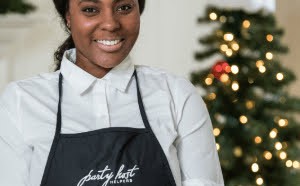 party host helper with christmas tree in background