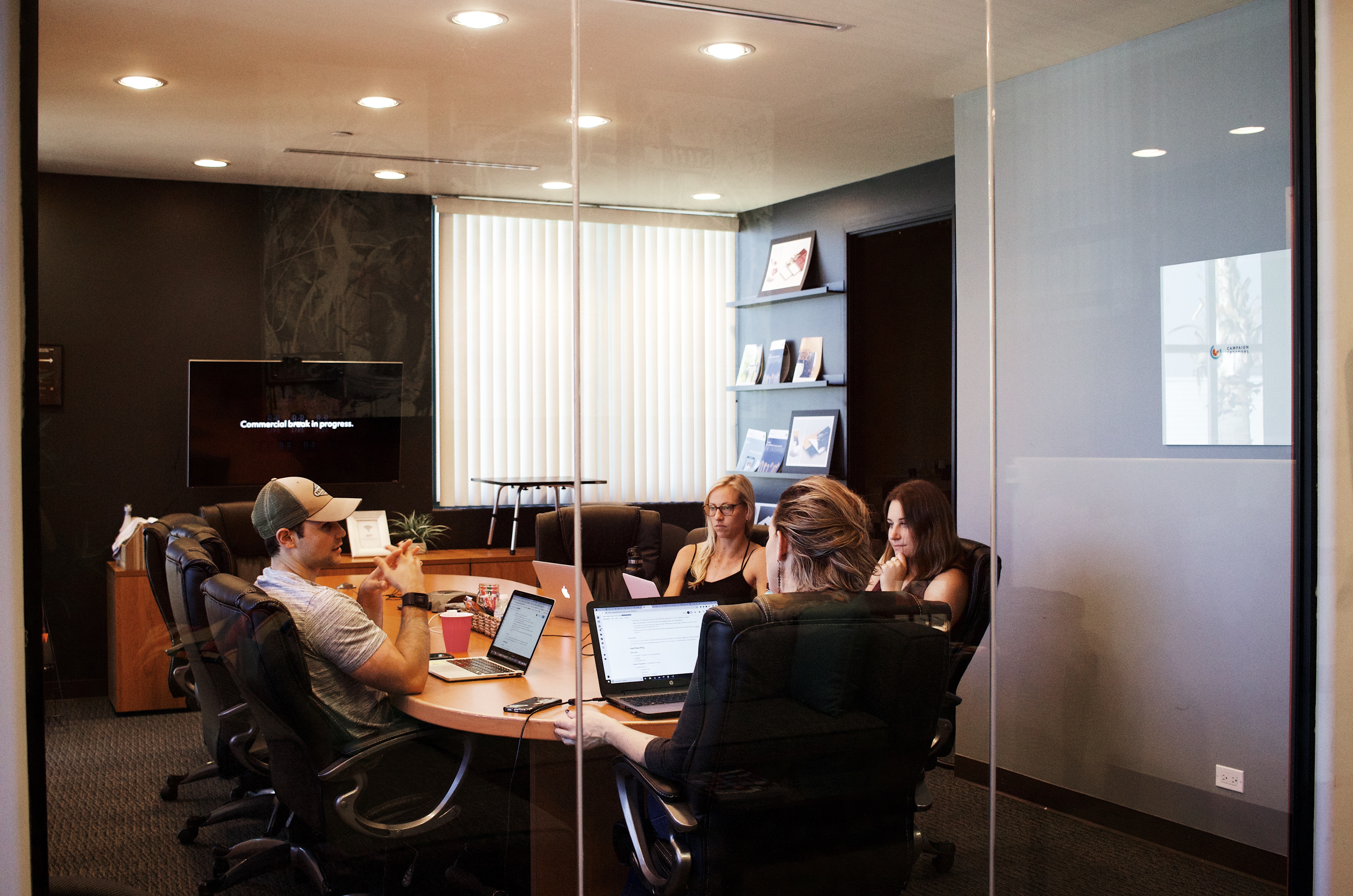 Office team meeting in a conference room behind glass doors