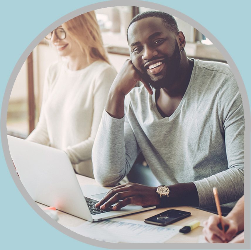 Businessman smiling while working at laptop