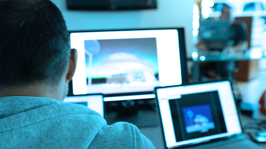 Image looks over shoulder of student sitting at computer studying Vectorworks Spotlight