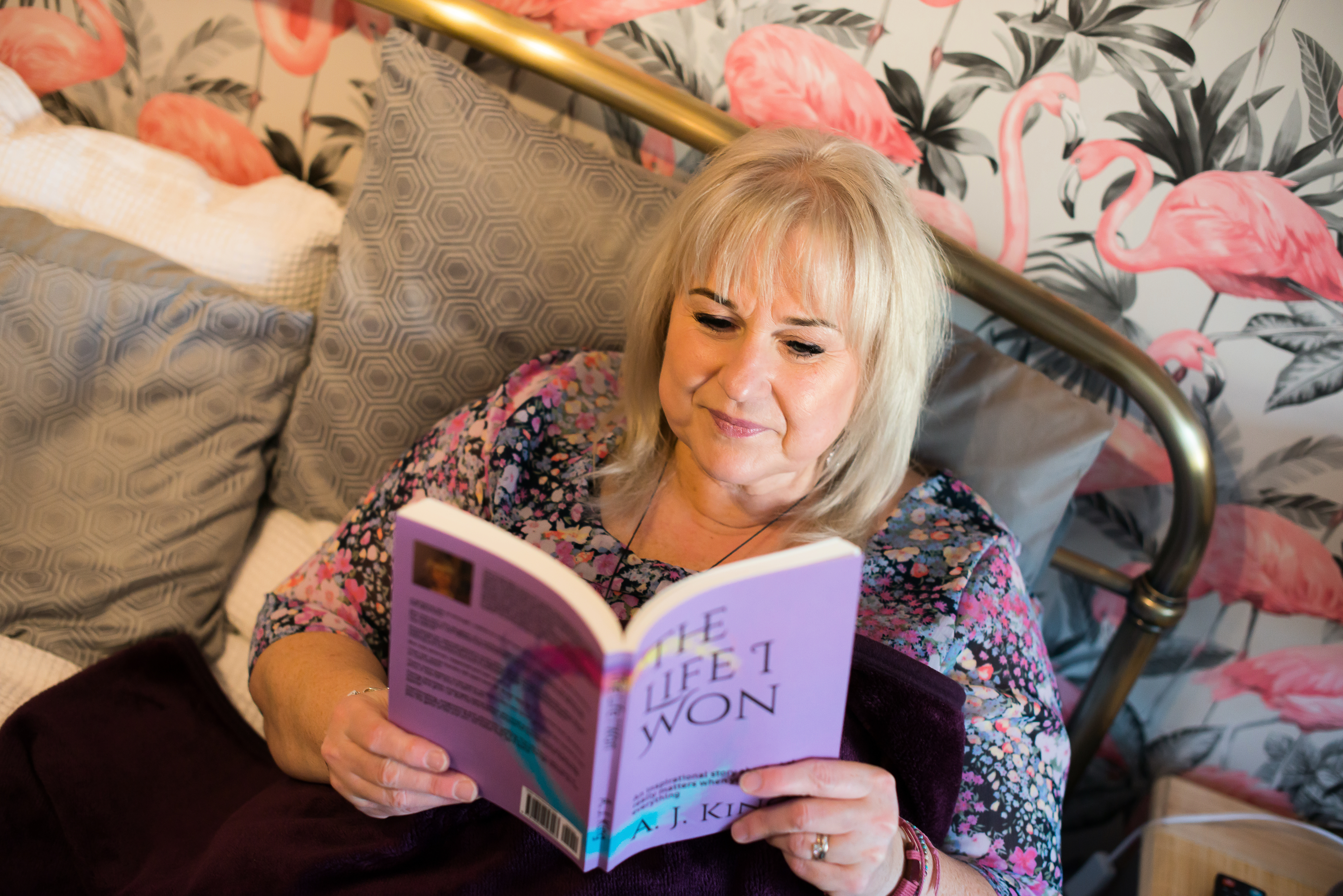 picture of a woman reading a book lying on a bed