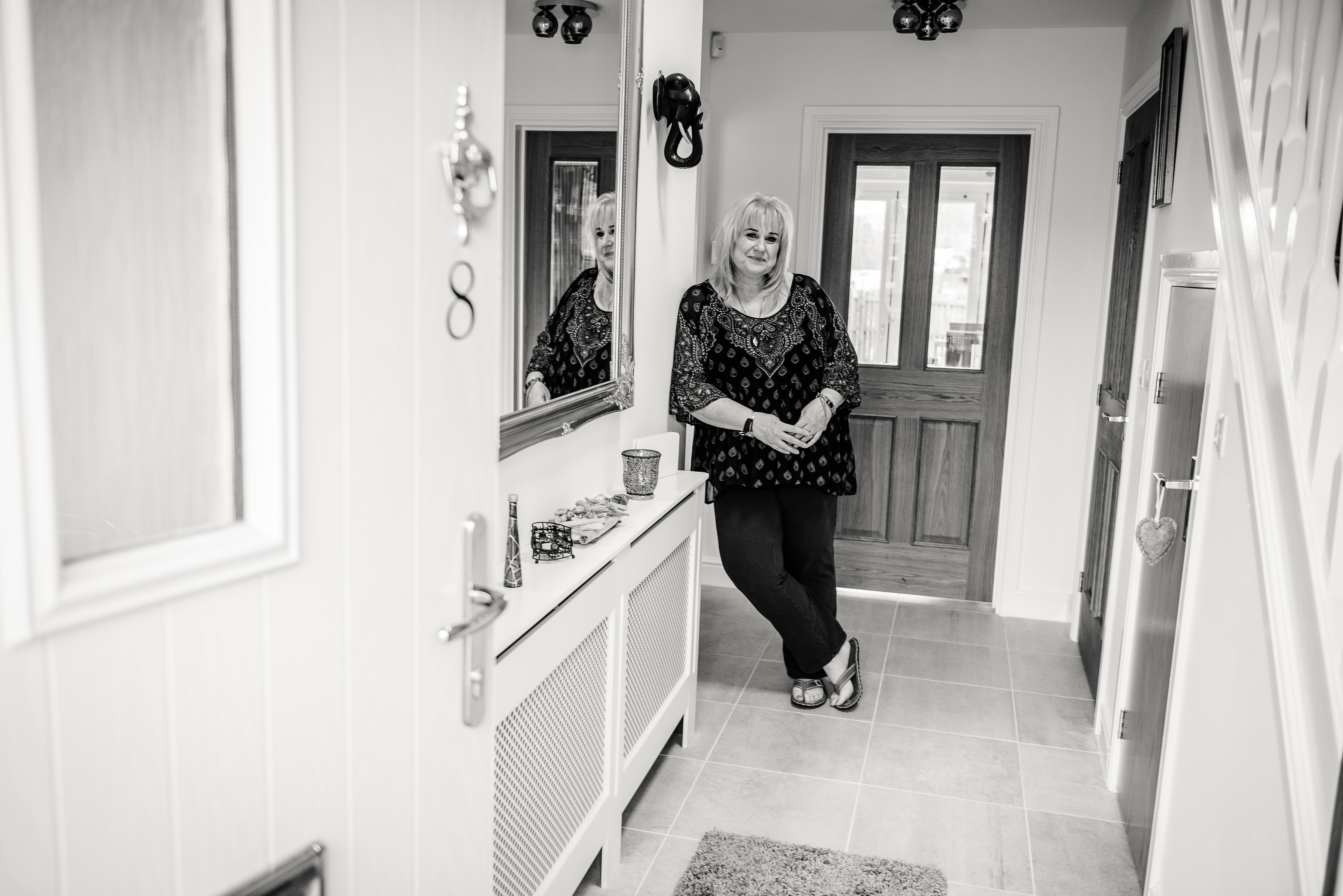 picture of a woman leaning against a wall in a hallway