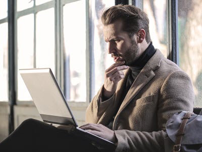 Man looking puzzled at laptop