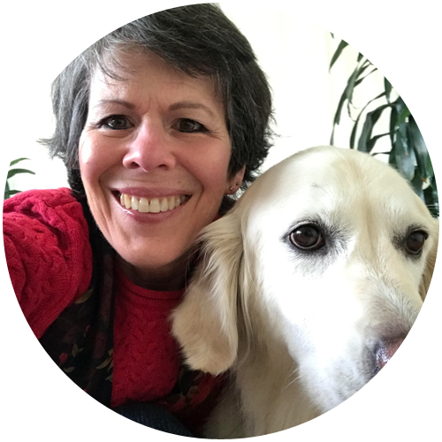 Dr. Barbara Cohen smiling and hugging her golden retriever