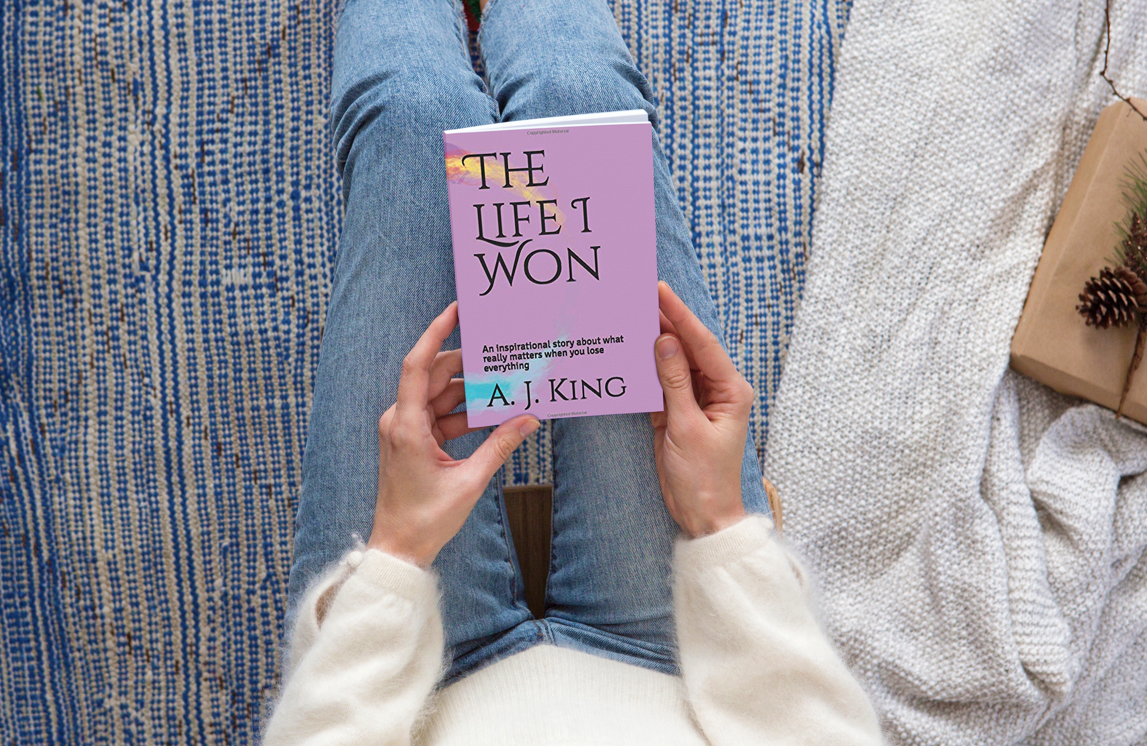 picture of a book with a violet cover being held by a woman over her lap